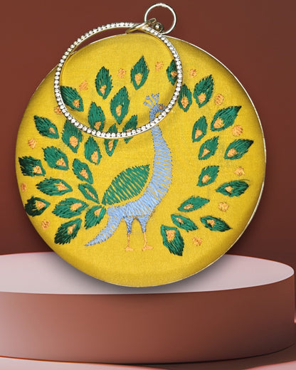 Embroidered clutch bag with peacock design on a yellow background